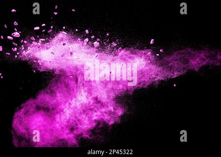 Spliss von Steinrückständen, der mit rosa Staubpulver auf schwarzem Hintergrund explodiert. Stockfoto