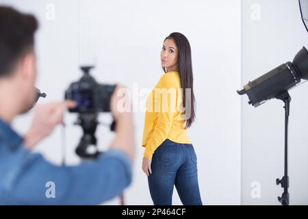 Professioneller Fotograf, der Bild und Modell im Studio prüft Stockfoto