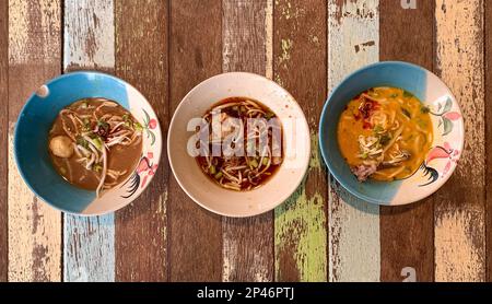 Thailändische Bootsnudeln in drei kleinen Schüsseln verschiedener Sorte. Draufsicht. Stockfoto