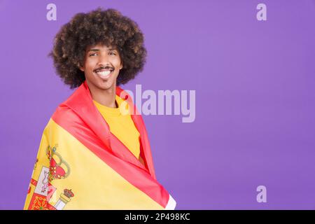 Lächelnder afrikanischer Mann mit spanischer Flagge Stockfoto