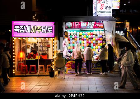 Ballon-Dart-Spielarkade und Wahrsager-Shop auf dem Haeundae Street Nachtmarkt für koreanische Reisende besuchen und spielen Ser Stockfoto