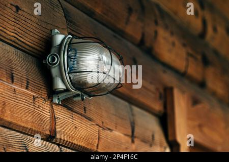 Außenwandleuchte an der Holztür der Unterkunft, selektiver Fokus Stockfoto