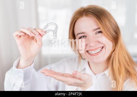 Frau schönes Lächeln, die eine transparente Öffnung Schutz Stockfoto