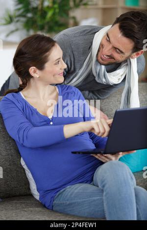 Glückliches Paar, das den pc zusammen überprüft Stockfoto