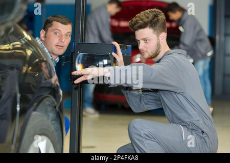 Garagenmechaniker mit Spiegelreflektor Stockfoto