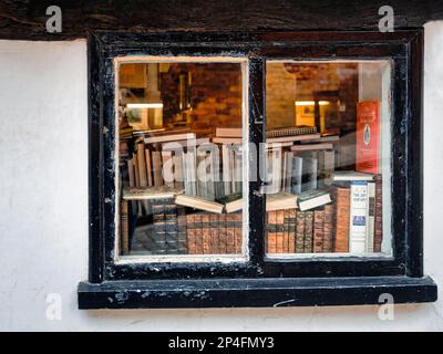 Sehen Sie durch ein altes Fenster auf Stapel von Büchern, Antiquarienbuchladen, Lincoln, Lincolnshire, England, Großbritannien Stockfoto