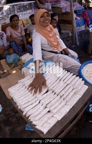 Frau, die Sojaerzeugnisse (Tempeh und Tofu) auf dem Markt verkauft, Kalabahi, Alor Island, Alor Archipel, Lesser Sunda Islands, Indonesien Stockfoto