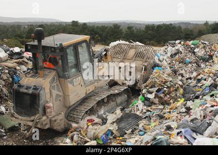 Bulldozer, der Müll auf einer Mülldeponie transportiert, Dorset, England, Großbritannien Stockfoto