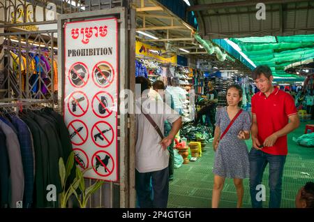 Ein Schild, das die Menschen vor der Liste der prohiobitierten Gegenstände warnt, die nicht auf dem Zentralmarkt in Phnom Penh, Kambodscha, mitgenommen werden dürfen. Die Liste enthält Waffen, Stockfoto