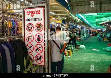 Ein Schild, das die Menschen vor der Liste der prohiobitierten Gegenstände warnt, die nicht auf dem Zentralmarkt in Phnom Penh, Kambodscha, mitgenommen werden dürfen. Die Liste enthält Waffen, Stockfoto