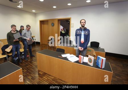 Augsburg, Deutschland. 06. März 2023. Ein 34-jähriger Mann steht auf dem Dock am Bezirksgericht, hinter Büchern, die sich mit dem Klimawandel befassen. Der Mann wird beschuldigt, die Regierung Schwabiens im Oktober 2022 trotz eines Verbots mit zwei anderen Personen besetzt zu haben und den damaligen Präsidenten der Regierung der Korruption beschuldigt zu haben. Kredit: Karl-Josef Hildenbrand/dpa/Alamy Live News Stockfoto