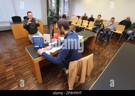 Augsburg, Deutschland. 06. März 2023. Ein 34-jähriger Mann sitzt hinter Büchern, die sich mit dem Klimawandel befassen, auf dem Dock am Bezirksgericht. Der Mann wird beschuldigt, die Regierung Schwabiens im Oktober 2022 trotz Hausverbot mit zwei anderen Personen besetzt zu haben und den damaligen Regierungspräsidenten der Korruption beschuldigt zu haben. Kredit: Karl-Josef Hildenbrand/dpa/Alamy Live News Stockfoto