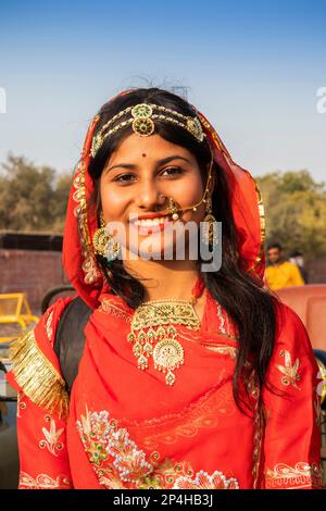 Indien, Rajasthan, Bikaner, Kamelfestivalparade, wunderschöne Rajasthani-Frau in rotem Sari Stockfoto