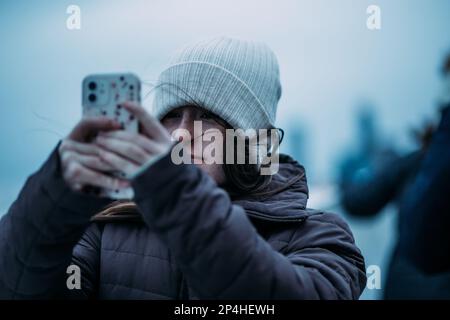 Teenager, die an einem kalten Tag ein Foto macht Stockfoto