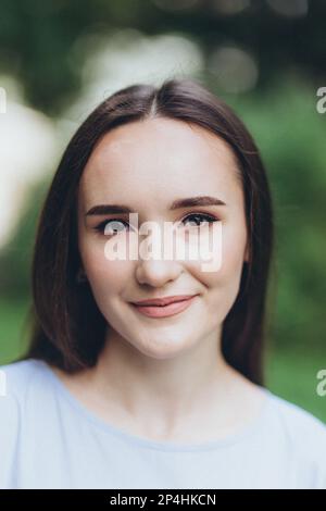 Porträt einer jungen brünetten Frau im Park Stockfoto