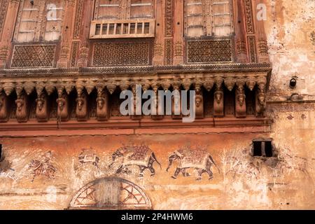 Indien, Rajasthan, Bikaner, Altstadt, historisches Haveli, Überreste von Wandgemälden der Elefantenparade unter kunstvoll verzierten Fenstern Stockfoto