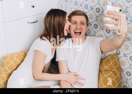Ein Paar in der Küche macht ein lustiges Selfie mit einer Sofortkamera Stockfoto