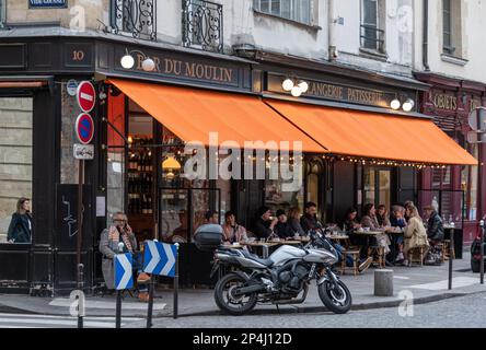 Gäste sitzen vor der Bar Moulin im 3. Arrondissement, Paris Stockfoto