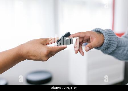 Hand des Arztes hält das Pulsoxymeter am Finger eines erwachsenen Patienten Stockfoto