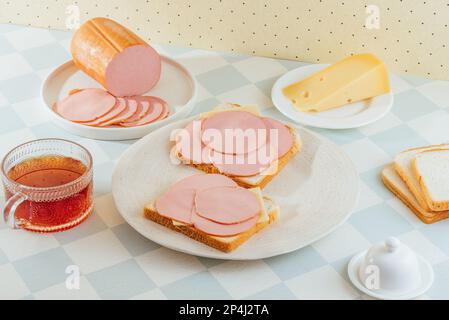 Schinken-Käse-Sandwich auf einem Teller. Ham ist in der Nähe. Frühstück. Stockfoto