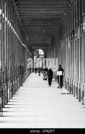 Symmetrisches Schwarz-Weiß-Foto der Arkade im Palais Royale im 1. Arrondissement, Paris. Stockfoto