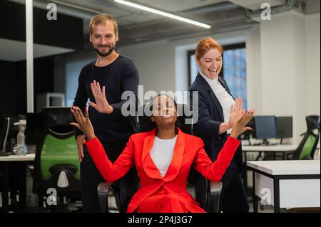 Weiß, rothaarige Frau, bärtiger weißer Mann, High, fünf afroamerikanische junge Frau im Büro. Stockfoto