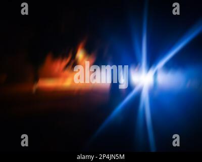 Verschwommenes Auto fährt schnell im modernen Nachthintergrund der Stadt. Unschärfe-Bild eines Autorads, das in der Nacht der Stadt treibt. Stockfoto