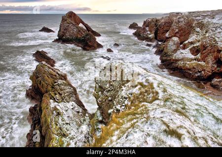 Blick auf den im Winter von Schnee bedeckten Bow Fiddle Rock, von der Klippe in der Nähe von Portknockie am Moray Firth in Muray, Schottland Stockfoto