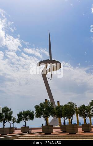 Barcelona, Spanien der Montjuic Communications Tower, umgeben von Bäumen unter dem Sonnenlicht und einem bewölkten Himmel in Spanien. Stockfoto