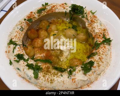 Nahaufnahme einer Schüssel Hummus auf einem Tisch. Arabische oder nahöstliche Küche. Stockfoto