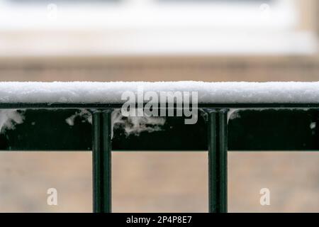 Grüner, eiserner Zaun mit einer Schneeschicht bedeckt, ein frostiger verschneiter holländischer Wintertag draußen mit Platz für Kopien. Stockfoto