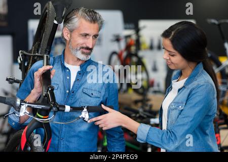 Ein Mann, der ein Fahrrad auf der Schulter trägt Stockfoto