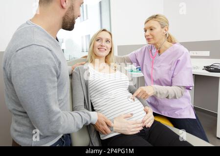 Arztberatung bei einem jungen schwangeren Paar Stockfoto