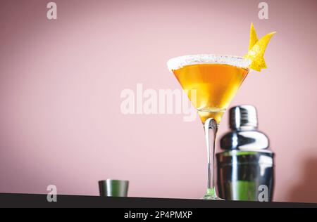 Alkoholischer Beiwagen-Cocktail mit Cognac, Likör, Zitronensaft und Eis. Pinkfarbener und grüner Hintergrund, Kopierbereich Stockfoto