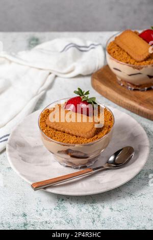 Hausgemachter Erdbeercreme-Pudding. Kekse und Erdbeerdessert. Türkisches Magnoliendessert in Glasschüssel Stockfoto