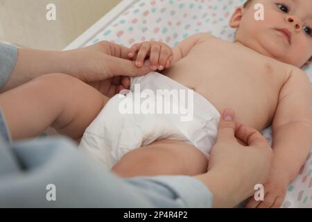 Mutter, die die Windel des Babys wechselt, auf dem Tisch, Nahaufnahme Stockfoto