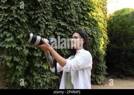 Schöne Frau mit Kamera, die Zeit im Naturschutzgebiet verbringt Stockfoto