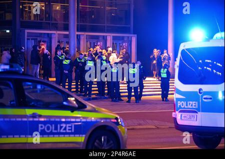 EINGEREICHT am 03. März 2023, Hamburg: Polizeibeamte stehen während der Operation mit Besuchern vor einem Kino. In mehreren Kinos in Deutschland und anderen Ländern gab es in den letzten Tagen Aufstände, während dort „Creed III“ gezeigt wurde. Auf dem TikTok-Netzwerk werden Videos der störenden Aktionen sehr aufmerksam. Foto: Jonas Walzberg/dpa Stockfoto