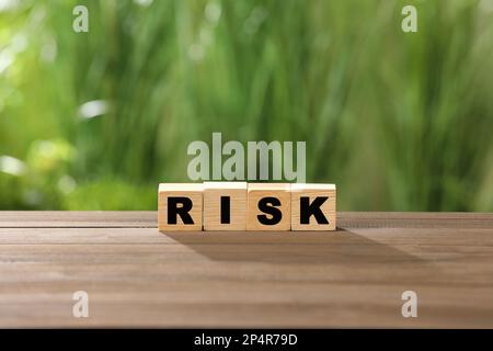 Würfel mit Wortrisiko auf Holztisch Stockfoto