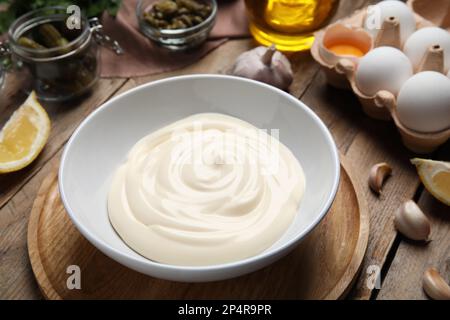 Zusammensetzung mit Zutaten für Tartarsauce auf Holztisch, Nahaufnahme Stockfoto