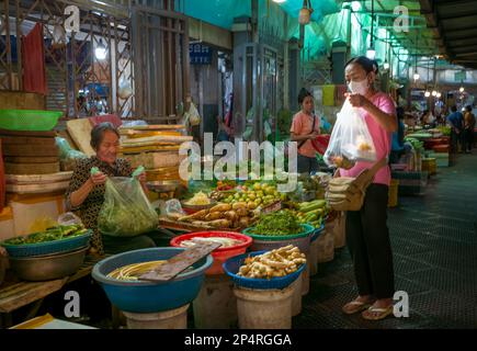 Eine kambodschanische Frau kauft Gemüse von einem Bauernhalter auf dem Central Market in Phnom Penh, Kambodscha. Stockfoto