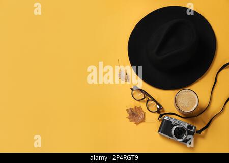 Flache Lagezusammensetzung mit stilvoller Mütze auf gelbem Hintergrund, Platz für Text Stockfoto