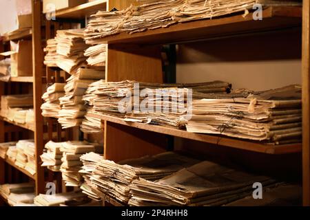 Sammlung alter Zeitungen auf Regalen in der Bibliothek Stockfoto