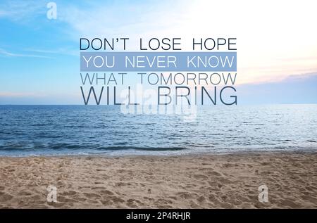Verlieren Sie nicht die Hoffnung, dass Sie nie wissen, was morgen bringt. Inspirierendes Zitat über Geduld, Selbstvertrauen und den nächsten Tag. Text gegen Sand Stockfoto