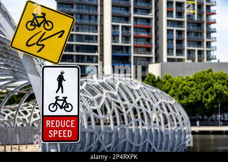 Melbourne webb Brücke über den Yarra River, mit Anweisungen für Radfahrer, Geschwindigkeit zu reduzieren und Fußgänger zu beachten. Jemand hat ein Googly-Eye hinzugefügt Stockfoto
