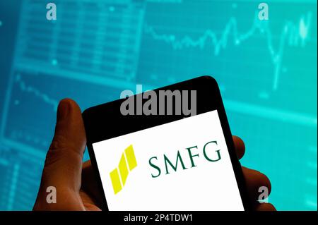 China. 19. Februar 2023. In dieser Fotoabbildung ist das japanische multinationale Bank- und Finanzunternehmen Sumitomo Mitsui Financial Group SMFG-Logo auf einem Smartphone mit einem Diagramm des Börsenindex im Hintergrund zu sehen. Kredit: SOPA Images Limited/Alamy Live News Stockfoto