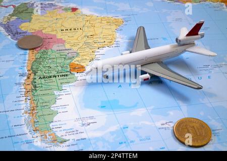 Buenos Aires, Argentinien - September 25 2016: Komposition aus einer Weltkarte, die in Südamerika zentriert ist, mit einem Spielzeugflugzeug, zwei Münzen. Alle Objekte Stockfoto