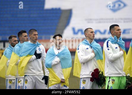 KIEW, UKRAINE - 4. MÄRZ 2023 - die Spieler des FC Dynamo Kiew in ukrainische Flaggen verpackt führen vor der ukrainischen Premie 2022-2023 die Nationalhymne auf Stockfoto