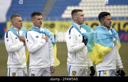 KIEW, UKRAINE - 4. MÄRZ 2023 - die Spieler des FC Dynamo Kiew in ukrainische Flaggen verpackt führen vor der ukrainischen Premie 2022-2023 die Nationalhymne auf Stockfoto