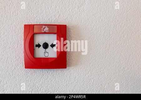 Brandmelder-Drucktaste an der Wand in der Schweiz. Stockfoto